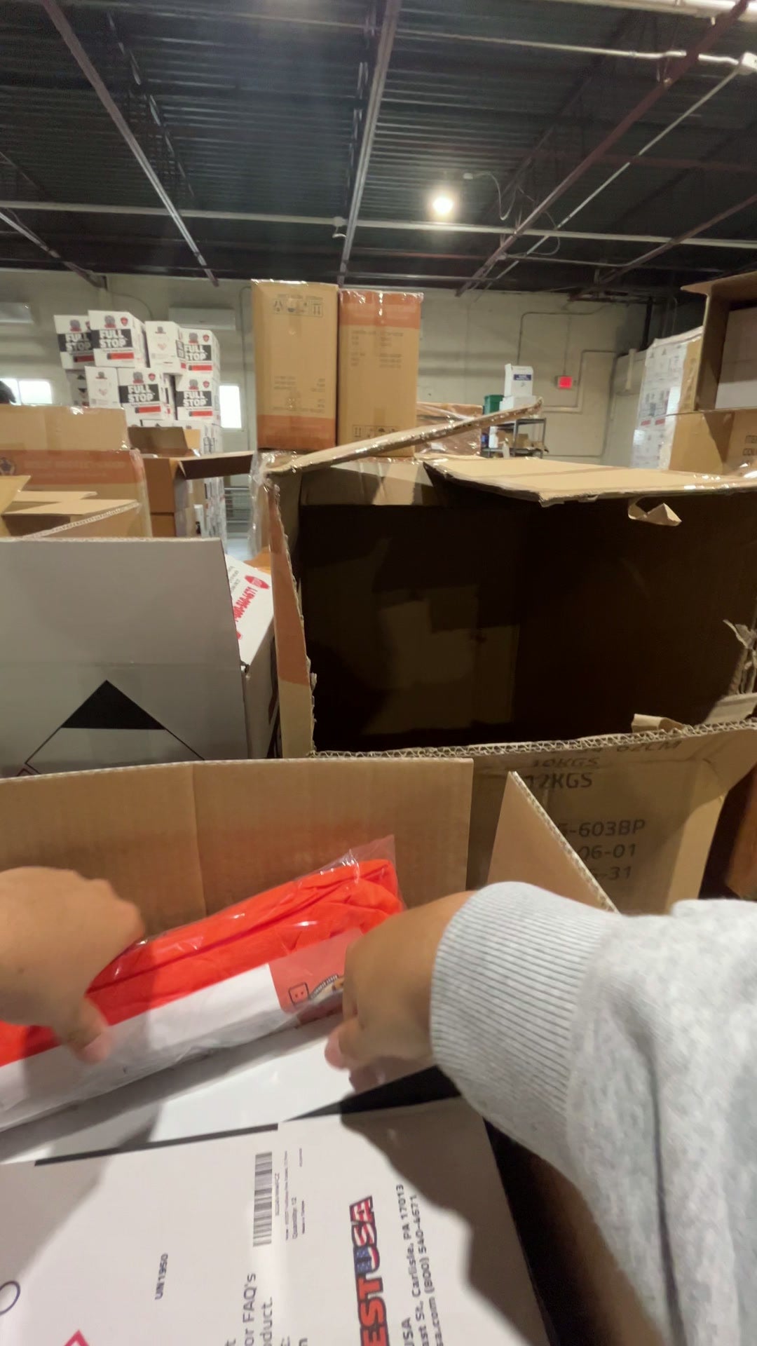 Hands placing accessories alongside a BEEST FullStop kit inside a shipping box
